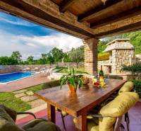 Außenbereich der Villa in der Stadt Bale mit Pool, Tisch und natürlichen Details.