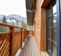Der Balkon der Hütte in Terchová mit Blick auf die verschneiten Berge und Wälder.