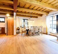 Offener Innenraum in einer Hütte mit Holzboden und Esstisch.