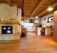 Innenraum der Hütte mit Kachelkamin, Holzdecke und Boden mit Holzdekor.