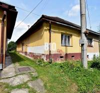 Ein Familienhaus in Partizánska Ľupča mit einem Hauch von Geschichte, umgeben von grünem Gras und einem Gehweg.