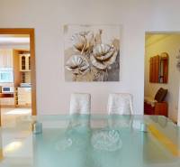 Esszimmer in einer 3-Zimmer-Wohnung mit einem Glastisch und einem Blumenbild an der Wand.