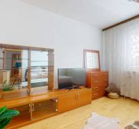 Helles Zimmer mit Vitrine, Fernseher, Kommode und Holzboden in einer 3-Zimmer-Wohnung.
