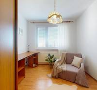 Ein Arbeitszimmer in einer 3-Zimmer-Wohnung mit Holzboden, einem Sessel und einem Schreibtisch.