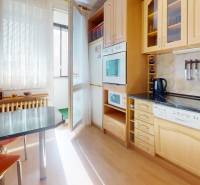 Küche in einer 3-Zimmer-Wohnung mit Holzboden und Zugang zur Loggia.