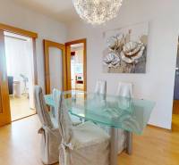 Esszimmer in einer 3-Zimmer-Wohnung mit einem Glastisch und einem Boden in Holzoptik.