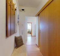 Der Flur in der 3-Zimmer-Wohnung mit einem Einbauschrank und einem Boden in Holzoptik.