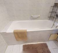 Badezimmer mit Badewanne, weißen Fliesen und hellem Bodenbelag in einer 3-Zimmer-Wohnung.