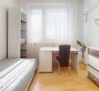 Ein Zimmer in einer 3-Zimmer-Wohnung mit einem Holzboden, einem Bett und einem Tisch.