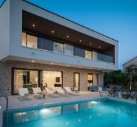 Villa in Bale mit Pool, Liegestühlen und Terrasse bei Sonnenuntergang.