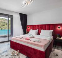 Ein Schlafzimmer in einer Villa mit einem großen Bett und Blick auf den See, Boden mit Marmormuster.