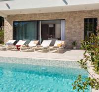 Außenbereich der Villa in Bale mit Pool und Liegestühlen auf der Terrasse.