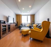 Wohnzimmer in einer 4-Zimmer-Wohnung mit Holzboden und gelben Sesseln.