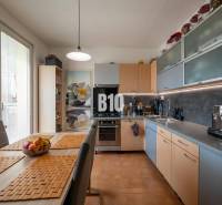 Küche in einer 4-Zimmer-Wohnung mit Esstisch und eingebauten Geräten.