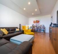 Wohnzimmer in einer 4-Zimmer-Wohnung mit Holzboden und bequemen Sitzgelegenheiten.