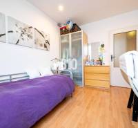 Ein Zimmer in einer 4-Zimmer-Wohnung mit einem Einzelbett, einem Schrank und einem Boden mit Holzdekor.