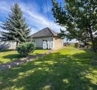 Ein Einfamilienhaus in Ondrejovce, umgeben von grünem Rasen und Bäumen in einem geräumigen Garten.