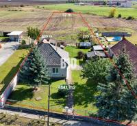 Ein Einfamilienhaus in Ondrejovce mit einem großen Grundstück, umgeben von ländlicher Landschaft.