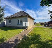 Ein Einfamilienhaus in Ondrejovce mit einem grasbewachsenen Hof unter blauem Himmel.