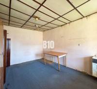 Ein Zimmerinterieur in einem Einfamilienhaus, das einen Teppich, Schränke und einen Tisch enthält.