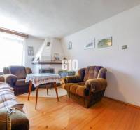 Ein Einfamilienhaus mit Kamin, bequemen Sesseln und einem Fußboden mit Holzdekor.