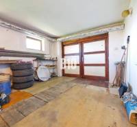 Garage in einem Einfamilienhaus mit Holztüren und einem Boden in Holzdekor-Optik.