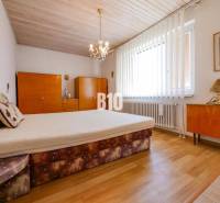 Schlafzimmer mit Holzboden in einem Einfamilienhaus, mit Möbeln und Kronleuchtern.