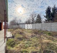 Der Bau eines Einfamilienhauses mit einem Rasenstück und einem Zaun, unter einem bewölkten Himmel.