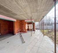 Der Bau eines Einfamilienhauses mit Ziegelwänden auf einem geräumigen Grundstück in der Natur.