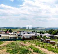 Ein Grundstück in Štitáre mit Bauplätzen, umgeben von Einfamilienhäusern und Natur.