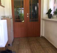 In einem Einfamilienhaus: Flur mit Türen, Boden mit Holzdekor, Pflanzen auf der Fensterbank.