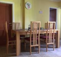 Esszimmer in einem Einfamilienhaus mit Stühlen und einem Tisch auf einem Boden mit Holzdekor.