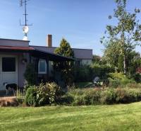 Ein Einfamilienhaus in Čierna Voda mit Garten, Hund und angrenzender Terrasse zum Entspannen.
