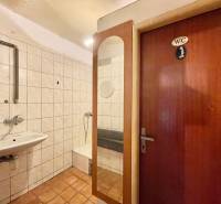 Badezimmer in einem Einfamilienhaus mit Waschbecken, Duschkabine und einer Tür mit der Aufschrift 