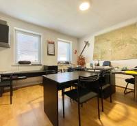 Büro in einem Einfamilienhaus mit einer Karte an der Wand und Möbeln für Arbeit und Besprechungen.