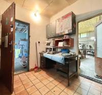 Innenraum von Geschäftsräumen mit Fliesenboden, Arbeitstisch und Werkzeugen auf den Regalen.