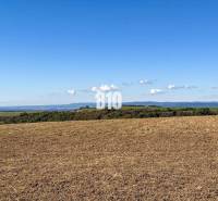 Flaches Land in Lackov mit Blick auf entfernte Hügel und blauen Himmel.