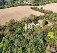 Eine Hütte in Lackov, umgeben von Wald und Feldern, eine ruhige ländliche Landschaft.