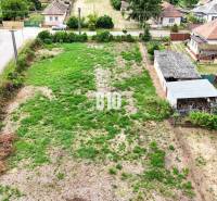 Grundstücke - Wohnen in Bardoňovo, zeigen ein bewaldetes Grundstück mit ländlichen Häusern im Hintergrund.