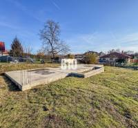 Baugrundstück mit Betonfundamenten und Grünflächen, ideal zum Wohnen.