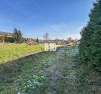 Auf dem Bild ist ein grünes Grundstück mit Häusern zu sehen, das sich zum Wohnen eignet.