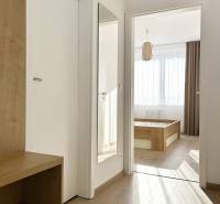 Der Flur in der 2-Zimmer-Wohnung mit einem Holzboden und einem Spiegel an der Wand.