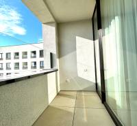 Der Balkon einer 2-Zimmer-Wohnung in der Karpatská-Straße in Poprad mit Blick auf ein niedrigeres Gebäude.