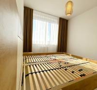 Schlafzimmer mit Bett und Lampe in einer 2-Zimmer-Wohnung mit Holzboden.