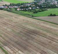 Landwirtschaftliche und forstwirtschaftliche Flächen in Nová Ves nad Váhom, umgeben von Dorfgebäuden und Grünflächen.