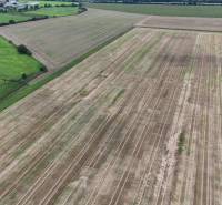 Ackerland in landwirtschaftlichen und forstwirtschaftlichen Flächen, Nová Ves nad Váhom, umgeben von grünen Wiesen.