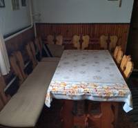 Esszimmer in einem Einfamilienhaus mit Holzstühlen und Tisch, an der Wand hängen Bilder und ein Kreuz.