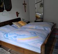 Schlafzimmer in einem Einfamilienhaus mit Holzelementen, großem Spiegel und Wanddekorationen.