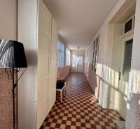 Ein Flur in einem Einfamilienhaus mit gemusterten Fliesen und einer schwarzen Lampe.