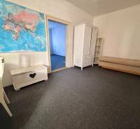 Ein Zimmer in einem Einfamilienhaus mit weißen Möbeln und einer Weltkarte an der Wand.